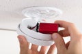 Person`s Hand Inserting Battery In Smoke Detector Royalty Free Stock Photo