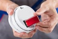 Person`s Hand Inserting Battery In Smoke Detector Royalty Free Stock Photo