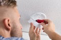 Person`s Hand Inserting Battery In Smoke Detector Royalty Free Stock Photo