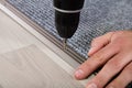 Person`s Hand Installing Carpet On Floor