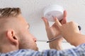 Person`s Hand Installing Smoke Detector On Ceiling Royalty Free Stock Photo