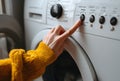 Person doing laundry, starting washing machine program Royalty Free Stock Photo