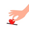 A person`s hand puts a heart in a donation box. the concept of kindness, generosity, love, donation