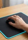 A person\'s hand rests on a computer mouse on a rectangular mouse pad. The mouse Royalty Free Stock Photo