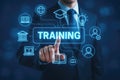 Person interacting with a digital interface displaying the word TRAINING and educational icons Royalty Free Stock Photo