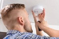 Person`s Hand Using Screwdriver To Install Smoke Detector Royalty Free Stock Photo