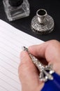 Person`s Hand Writing with a Metal Fountain Pen with Gall Bottle and Pen Holder Royalty Free Stock Photo