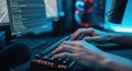 Close up of hands typing on a glowing mechanical keyboard in a dimly lit room with a computer screen displaying code Royalty Free Stock Photo