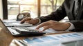 A person's hands interact with a tablet displaying financial graphs, indicating a professional setting where