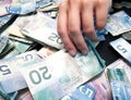 Person's hands picking Twenty Canadian Dollar Bill