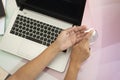 Person sanitizing the hands with a sanitizer before working with a laptop