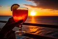 person, savoring exotic cocktail with view of the sunset on the beach