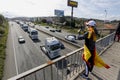 Person with the scarf and the national flag of Spain recording with the mobile the passage of the slow march of trucks protesting