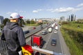 Person with the scarf and the national flag of Spain recording with the mobile the passage of the slow march of trucks protesting