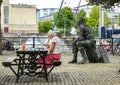 Person seated and John Cabot statue at Bristol Docks near Arnolfini, Bristol,