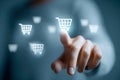 Person selecting an online shopping cart icon on a digital interface representing e-commerce and virtual purchasing technology in Royalty Free Stock Photo
