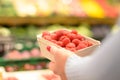 Person selecting a punnet of fresh raspberries