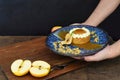 Person serving Apple tart with fresh apples on wooden table