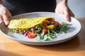 person serving colorful veggie omelette on plate