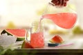 Person serving freshly prepared refreshing watermelon drink on kitchen bench