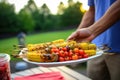 person serving plated grilled corn