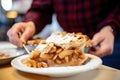 person serving a slice of apple pie