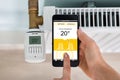 Person Setting Temperature Of Thermostat Using Mobilephone