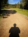 Person shadow sport while running on a forest trail