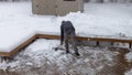 Person shoveling deep snow off a wooden deck