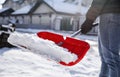 Person shoveling snow outdoors on winter day, closeup