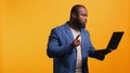 Person showing disagreeing sign during meeting using laptop, studio background