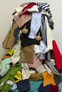 Person showing thumbs up from inside of huge pile of different mixed up clothes
