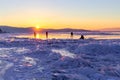 Person silhouette on lake ice and winter colorful sky during sunset. Lake Baikal, Russia