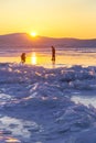 Person silhouette on lake ice and winter colorful sky during sunset. Lake Baikal, Russia