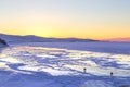 Person silhouette on lake ice and winter colorful sky during sunset. Lake Baikal, Russia