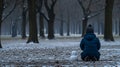 Person sits by snowman in snowy park Royalty Free Stock Photo