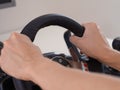 A person sitting behind a computer and holding the steering wheel of a driving simulator Royalty Free Stock Photo
