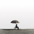 A person sitting on a bench with an umbrella