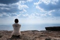 A person sitting on rocky mountain looking out at scenic natural view Royalty Free Stock Photo