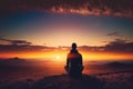 person, sitting in silent meditation, with view of beautiful sunset