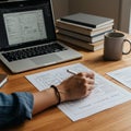 A person is sketching website wireframes on paper at a wooden desk. Nearby
