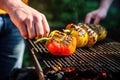 person skewering bell pepper on a grill