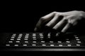 A person skillfully types on a keyboard in the dark, highlighting their proficiency in the digital realm, A visually striking