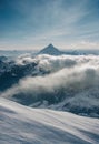 a person on skis is standing on a snowy mountain top with a view of the clouds and mountains Royalty Free Stock Photo