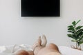 Person sleeping on the bed and watching television. Concept of stay at home. Royalty Free Stock Photo