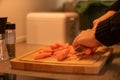 Person slicing carrot on wooden cuttingboard Royalty Free Stock Photo