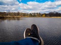 Person With Sneakers And Jeans Relaxing Legs Over Waters Edge, Relaxation Concept Royalty Free Stock Photo