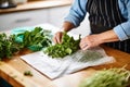 person sorting fresh herbs from bag onto board