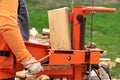 person splitting firewood on a splitter machine, outdoors