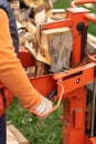 person splitting firewood on a splitter machine, outdoors